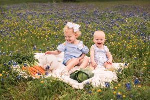 Photo of brother and sister with bunny in flowers