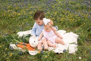 Photo of brother and sister with bunny in flowers
